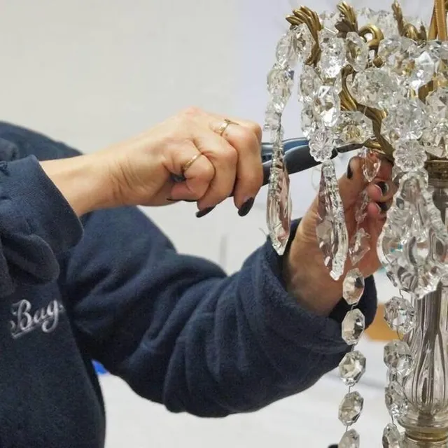 photo carole besnard détache et remplace une à une les attaches des cristaux d’un lustre pour le rénover.  ©  ouest-france
