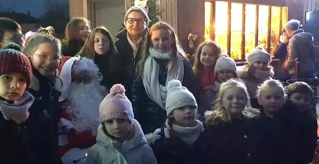photo  les enfants de la commune, tout sourire, reçoivent leurs cadeaux des mains du père noël.  &copy;  le maine libre 