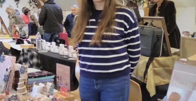 photo  dorine lenormand devant ses créations en tissu lors du marché de noël de la maison du gasseau.  &copy;  le maine libre 
