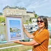 photo  catherine paulouin, de l’office de tourisme vallée de la sarthe, posant ici avec l’affiche vintage de sablé-sur-sarthe, en juillet 2024. 
