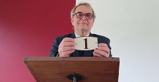 photo  jean-louis lemarié, maire d’asnières-sur-vègre, présente la nouvelle plaque destinée aux habitations lors des vœux dans la salle de la marbrerie, le 12 janvier.  &copy;  ouest-france 