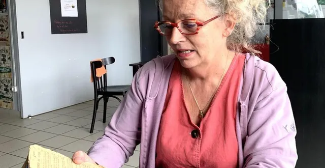 photo  nelly devant le précieux livre de recettes de sa grand-mère.  &copy;  les ateliers d’histoire de la charnie. 