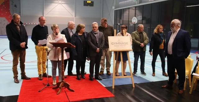 photo  andré trottet, à droite, accompagné des membres du conseil municipal avec la plaque du gymnase à son nom.  &copy;  le maine libre 