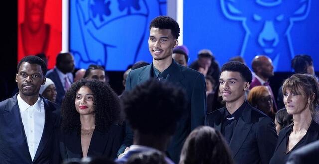 photo  ève et oscar (à gauche et à droite de victor wembanyama) avec leur frère et leurs parents lors de la draft nba de « l’alien » à brooklyn, en juin 2023.  ©  photo : timothy a. clary / afp 