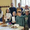 photo  parents et enfants devant leurs réalisations lors du concours de galettes des rois. 