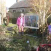 photo  gine guibout dans son jardin, présente une de ses toiles qui sera exposée à la blanchère 