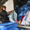 photo  à emmaüs, les vêtements n’étant pas en assez bon état pour être vendu sont stockés dans ces sacs bleus avant d’être recyclés. 