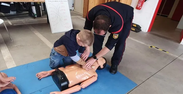 photo  un pompier volontaire montrant les gestes de premiers secours a un jeune visiteur.  &copy;  ouest-france 