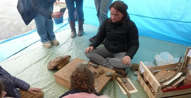photo  avec agathe, bénévole au sein de l’association jean jousse, les jeunes élèves apprennent à allumer le feu par percussion.  &copy;  le maine libre 
