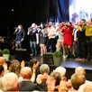 photo  les chanteurs et bénévoles réunis sur scène pour un final chaleureux, sous les applaudissements d’un public conquis. 