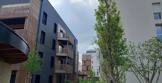 photo  au cœur de l’îlot résidentiel, à gauche, un des deux garages à vélos en terre crue puis l’immeuble totalement en bois, au fond et à droite, les 2 immeubles en béton bas carbone, et le jardin et l’allée végétalisée  &copy;  ouest-france 