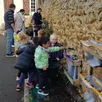 photo les petits jardiniers en herbe de l’école du sacré-cœur, au travail pour créer leur jardin éducatif avec l’aide des artisans du végétal.
