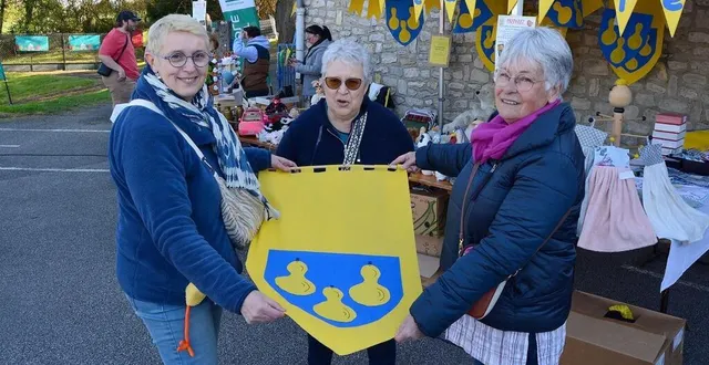 photo  florence gautier à gauche, en compagnie de martine mezières et de magdeleine paineau, présente un exemple d’étendard pour décorer la prochaine fête du chausson aux pommes.  &copy;  ouest-france 