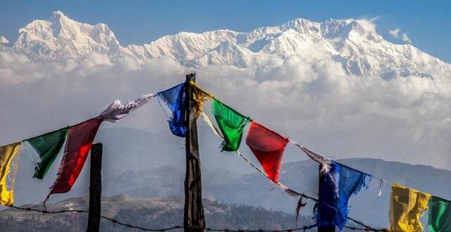 photo des drapeaux de prière colorés flottent devant le majestueux kanchenjunga, le troisième plus haut sommet du monde, sandakphu, bengale occidental, inde, asie. © robertharding via afp