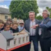 photo un groupe d’enfants contemple la maquette sous les regards amusés du maire et de l’artiste.