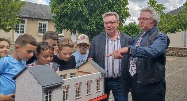 photo  un groupe d’enfants contemple la maquette sous les regards amusés du maire et de l’artiste.  &copy;  le maine libre 