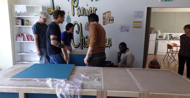 photo  les personnes en formation au greta installent le meuble de caisse qu’ils ont réalisé.  &copy;  le maine libre 