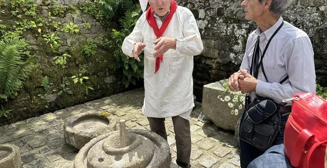 photo  claude boscher (à gauche) a pu expliquer comment faisaient nos ancêtres pour faire de la farine avec des moulins à bras.  &copy;  ouest-france 