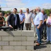 photo  sous les regards d’andré trottet, (à droite), frédéric barbier, (3e à droite), des élus, quentin spooner, truelle en main, a répandu le ciment nécessaire à la pose de la première pierre. 