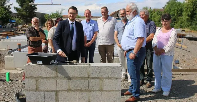 photo  sous les regards d’andré trottet, (à droite), frédéric barbier, (3e à droite), des élus, quentin spooner, truelle en main, a répandu le ciment nécessaire à la pose de la première pierre.  &copy;  ouest-france 