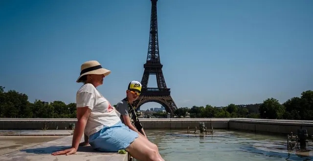 photo  des touristes se rafraîchissent dans la fontaine du trocadéro, en face de la tour eiffel à paris, le 1er juillet 2025.  &copy;  photo : afp/dimitar dilkoff 