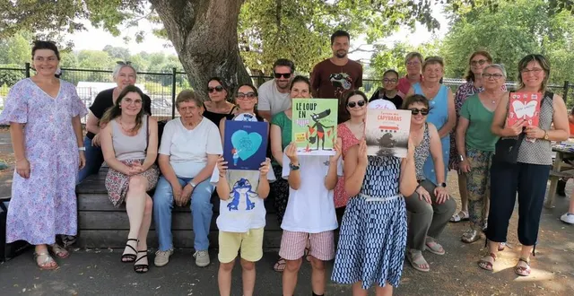 photo  les enfants lauréats se cachent derrière leur livre cadeau, derrière eux, les enseignants et manon geslin, médiathécaire (assise à gauche) qui a géré l’événement.  &copy;  le maine libre. 
