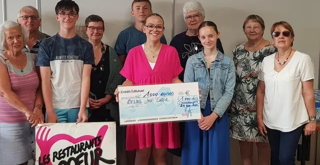 photo  les collégiens, fiers de leur don, posent avec les membres de l’association des restos du cœur.  &copy;  co. 