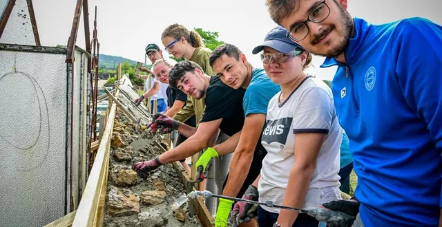 photo  à aubigné-racan, des jeunes de huit nationalités différentes refont le mur du cimetière avec des pierres et de la chaux.  &copy;  photo le maine libre - yvon loué 