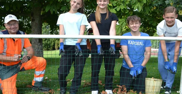 photo  encadrés par cyril coutelle, quatre des six jeunes qui participent au dispositif argent de poche, sur le stade de foot.  &copy;  le maine libre 