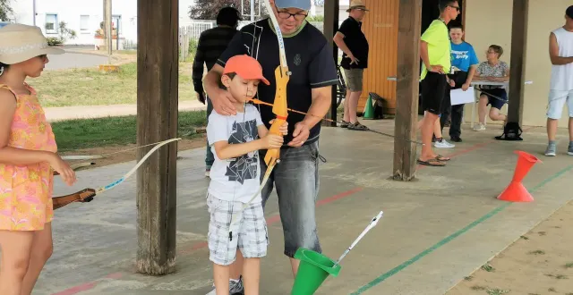 photo  noël guide son fils ilan, 8 ans, sur sa façon de tenir son arc, sa fille salomé, attend son tour.  &copy;  le maine libre. 
