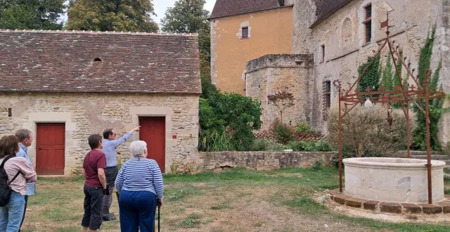 photo  philippe favre, à gauche, montre du doigt la façade arrière du logis de moullins en expliquant son architecture.  &copy;  le maine libre 