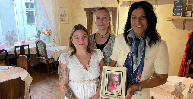 photo  orit taylor tenant le portrait de son défunt mari robert, avec les deux employées du café d’orée, cindy et loulou.  &copy;  le maine libre 