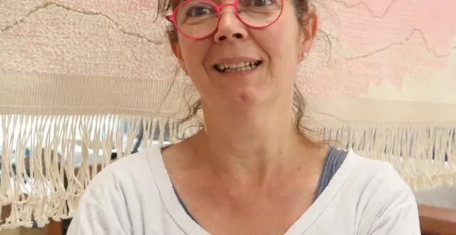 photo  sandrine pincemaille pose devant l’une de ses dernières tapisseries, « l’aiguille verte », née d’un séjour en montagne.  &copy;  co. 