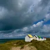 photo  les célèbres cabines aux toits de couleur de gouville-sur-mer (manche) prennent du relief sous un ciel orageux capté par @emmyld.studio, le 13 juillet. 