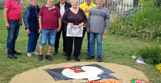 photo  en pleine création de la fresque, elena nova, plan à la main, entourée de son mari, de l’équipe du jardinier sarthois et de jacques royer, président du comice.  &copy;  le maine libre 
