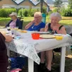 photo  les habitants d’un des béguins de mûrs-érigné partageant un repas dans le parc du béguinage. 