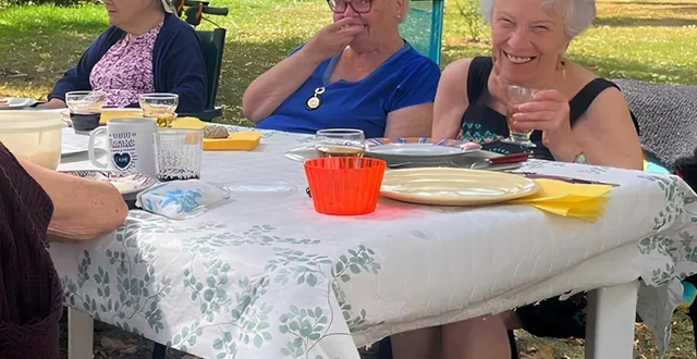 photo  les habitants d’un des béguins de mûrs-érigné partageant un repas dans le parc du béguinage.  &copy;  vivre en béguinage 