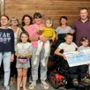 photo l’association des trois monts entourant alexis (11 ans) atteint d’une amyotrophie spirale et noée, petite fille porteuse de deux anomalies chromosomiques.