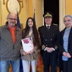 photo  kartal nur, entourée de ses parents et du préfet de l’orne, hervé tourmente, tient fièrement son livret de nationalité française. 