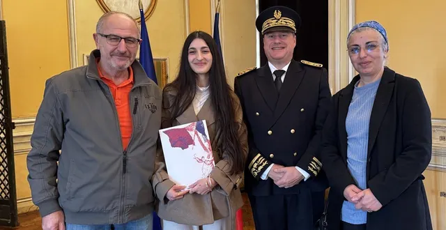 photo  kartal nur, entourée de ses parents et du préfet de l’orne, hervé tourmente, tient fièrement son livret de nationalité française.  &copy;  ouest-france 