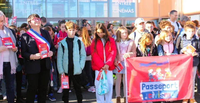 photo  sandrine plessix (à gauche, écharpe tricolore) et les élèves de cm2 réunis devant l’espace saugonna pour la remise du passeport du civisme.  &copy;  le maine libre 