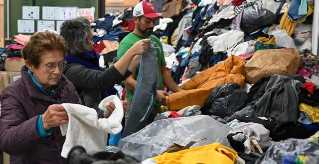photo  saint-jean-de-linières, le 15 octobre 2025. bénévoles, compagnes et compagnons peinent à venir à bout de la montagne de textiles récupérés par l’association.  &copy;  co – laurent combet 