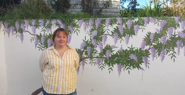 photo  andréa johanna-moulin devant une fresque réalisée sur un mur de sa maison.  &copy;  ouest-france 