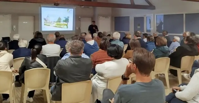 photo  un aperçu des personnes présentes à la réunion publique présentée en diaporama par m. adam debout près de l’écran.  &copy;  co 