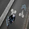 photo un cycliste circule à vélo sur une piste cyclable distincte de la chaussée pour véhicules à moteurs.