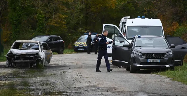 photo  des enquêteurs à proximité de la voiture incendiée du suspect, mercredi 5 novembre.  &copy;  christophe archambault / afp 