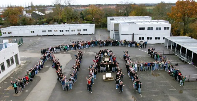 photo  joli symbole de la journée, dans la cour du collège, les élèves se sont répartis pour former les lettres nah, non au harcèlement.  &copy;  collège molière 