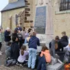 photo  les élèves, leur instituteur, et françoise lambert, référente historique, inspectent et étudient le monument aux morts de changé. 
