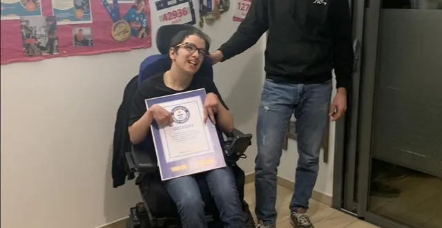 photo  amélie, dans sa chambre avec simon, au milieu de leurs dossards, record du monde en main.  &copy;  co 