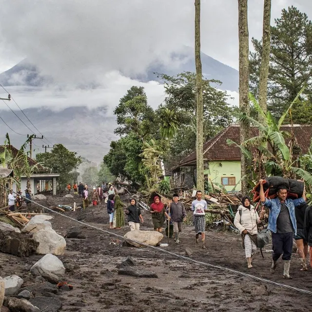 photo des personnes marchent sur un sol recouvert de cendres volcaniques après une coulée pyroclastique lors de l’éruption du mont semeru, dans le village de supiturang, à lumajang, sur l’île de java, le 20 novembre 2025.  ©  agus harianto/afp